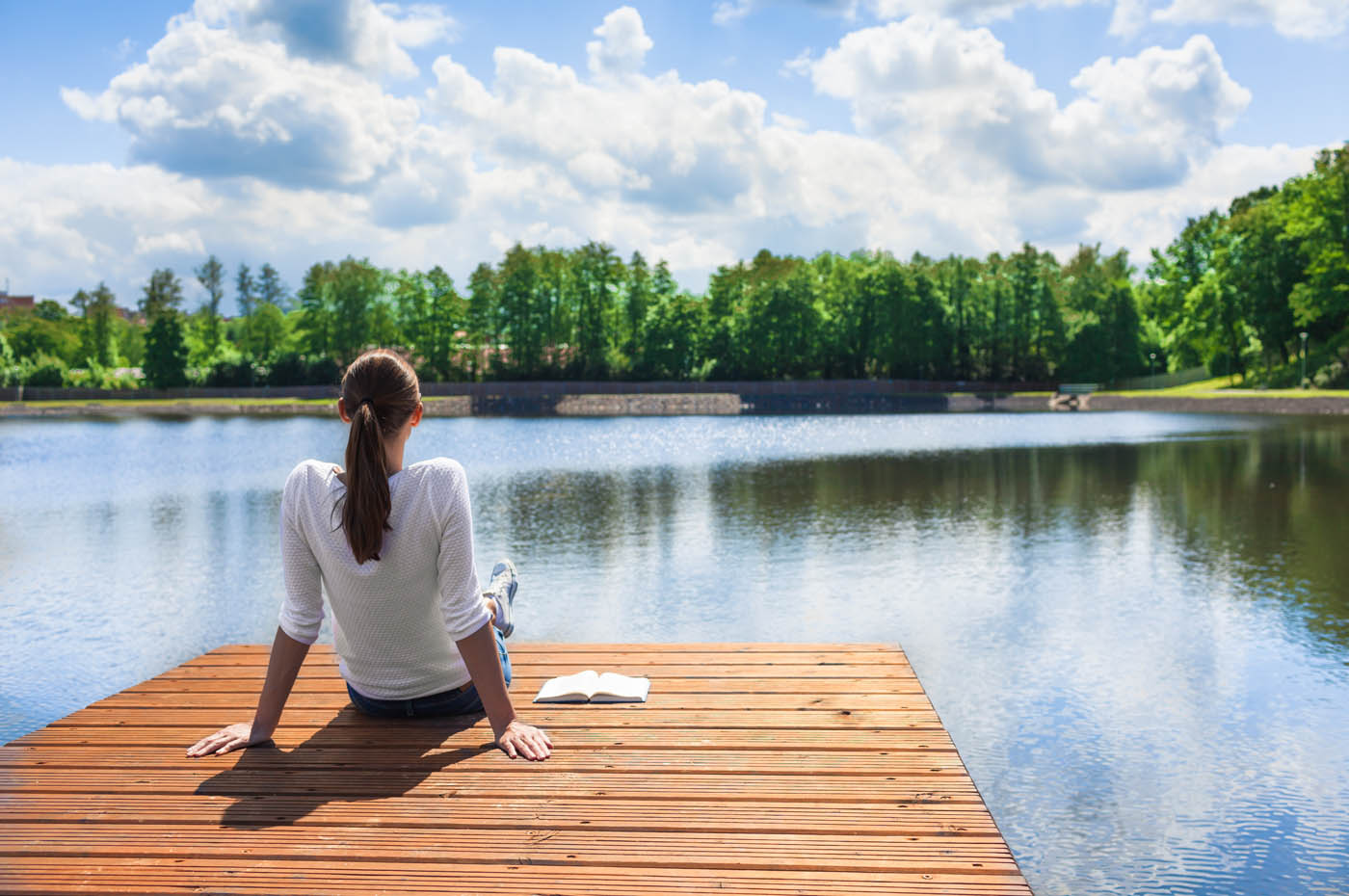 A woman sitting outside on a dock - Hello Pest Control offers expert insect control in Westchester County, NY to protect you from all types of pesky bugs.