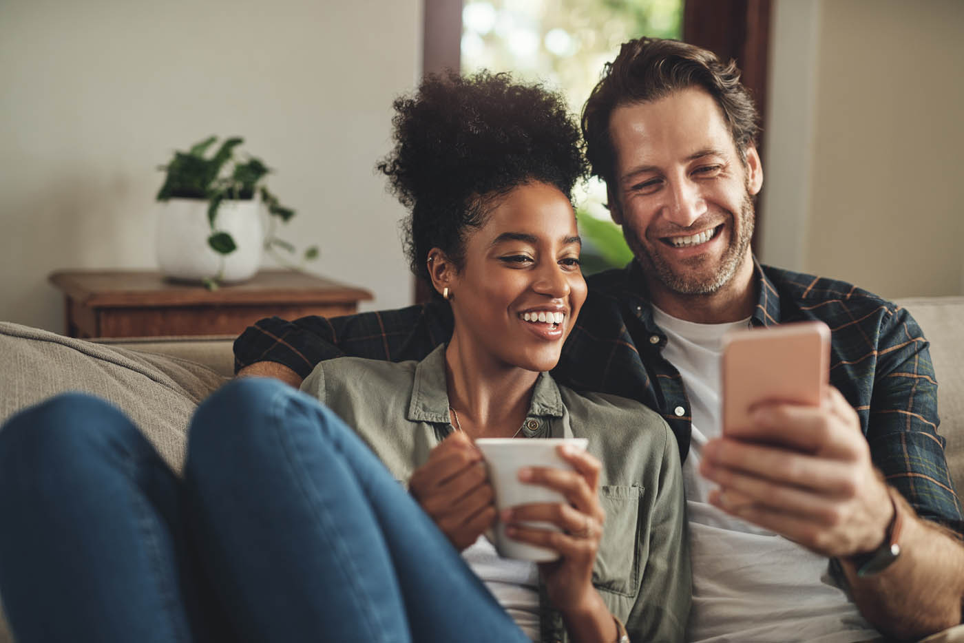 A couple sitting on their couch inside their pest-free home - book your pest control service in North Salem, NY with Hello Pest: a company that cares.